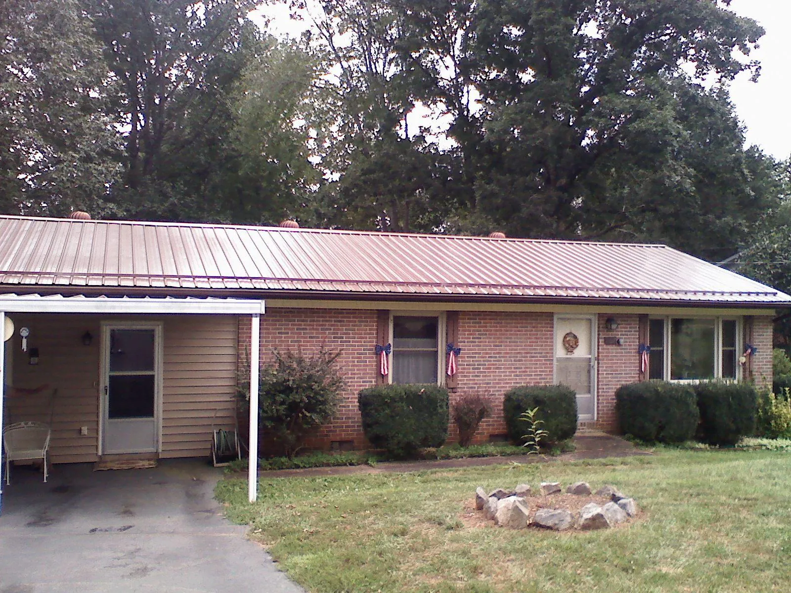 Bronze metal roof and carport on a brick ranch home — Roof Repair work by our crew in Newfoundland